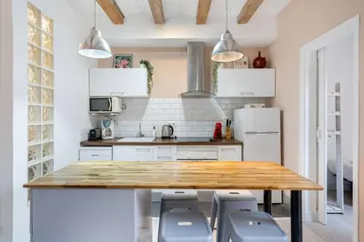 a kitchen with a wooden table and chairs at Sunny Retro Flat Balcony in Poble Sec in Barcelona