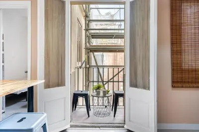 an open door to a balcony with a table and chairs at Sunny Retro Flat Balcony in Poble Sec in Barcelona