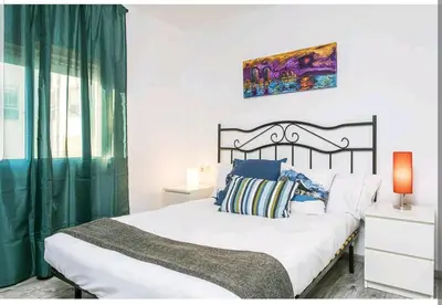 a bedroom with a large bed with a green curtain at Apartamento BB in Hospitalet de Llobregat