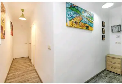 a hallway with a painting hanging on a wall at Apartamento BB in Hospitalet de Llobregat