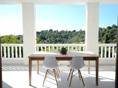 a wooden table on a porch with two chairs at Apartamento nuevo muy luminoso in La Crehueta