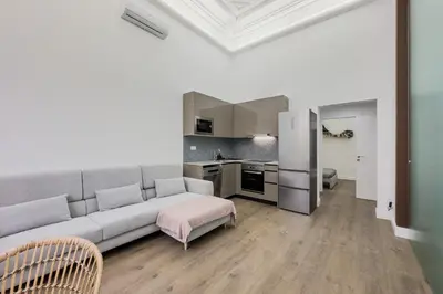 a living room with a couch and a kitchen at Apartamento Rambla Cataluña 35 in Barcelona