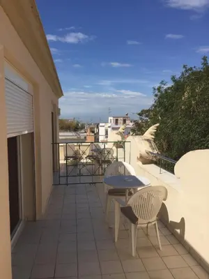 a balcony with two chairs and a table at Hotel Noucentista in Sitges