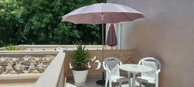 a table and chairs and an umbrella on a patio at Hotel Noucentista in Sitges