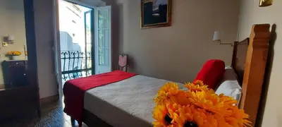 a bedroom with a bed with yellow flowers on it at Hotel Noucentista in Sitges
