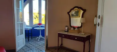 a room with a mirror and a table with a window at Hotel Noucentista in Sitges
