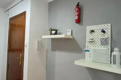 a bathroom with white shelves and a fire extinguisher on the wall at Apartamento Gran Via para 6 en el centro de Premià in Premiá de Mar