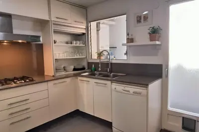 a kitchen with white cabinets and a sink at Apartamento Gran Via para 6 en el centro de Premià in Premiá de Mar