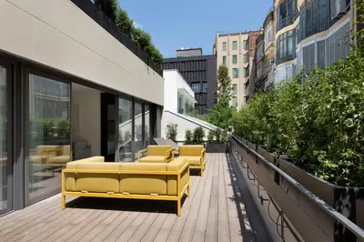a row of yellow benches on a balcony of a building at The Passage Homes - Simaba Group in Barcelona