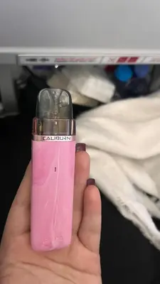 a person holding a pink lighter in their hand at just a dirty sofa in Barcelona