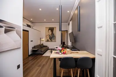 a kitchen and living room with a table and chairs at beautiful cosy modern apartment ,19th century building in Barcelona