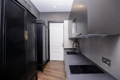a kitchen with black cabinets and a white door at beautiful trendy spacious apartment very central location in Barcelona