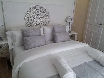 a bedroom with a white bed with pillows at Sitges Centre Mediterranean House- 5 Bedroom, 4 Bathroom, Terrace Courtyard, Private Rooptop Pool in Sitges
