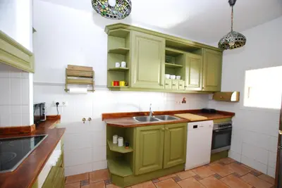 a kitchen with green cabinets and a sink at Masnou Chill in Masnou