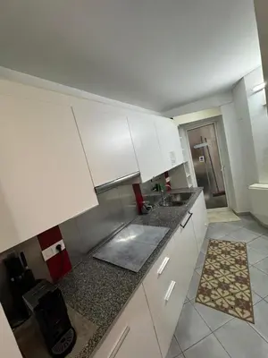 a kitchen with white cabinets and a sink at Tranquilo y céntrico in Barcelona