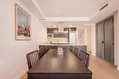 a kitchen and dining room with a wooden table and chairs at Sweett - Harmony Central in Barcelona