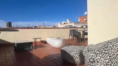 a patio with a couch and a table on a roof at Top Studio with Terrace in Barcelona
