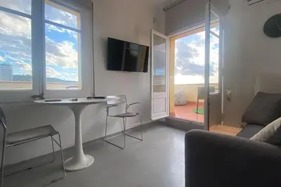 a living room with a couch and a table and a television at Top Studio with Terrace in Barcelona