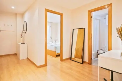 a living room with a bed and a mirror at Winahost Barcelona Provenza in Barcelona