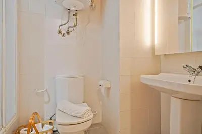 a white bathroom with a toilet and a sink at Winahost Barcelona Provenza in Barcelona