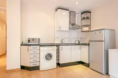 a kitchen with a washing machine and a washer at Winahost Barcelona Provenza in Barcelona