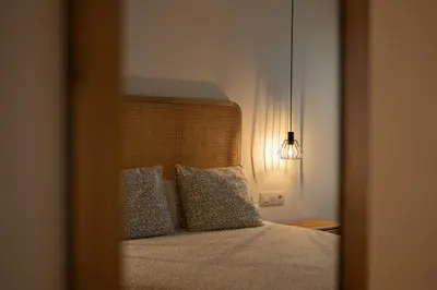 a reflection of a bed with pillows in a mirror at El Niu Apartamentos con terraza Camp Nou in Hospitalet de Llobregat