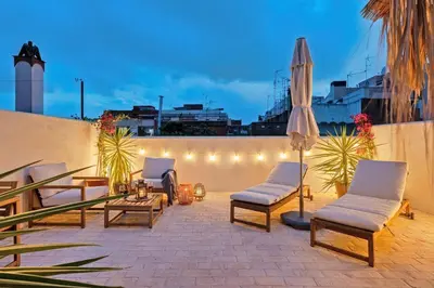 a patio with chairs and an umbrella and lights at El Niu Apartamentos con terraza Camp Nou in Hospitalet de Llobregat