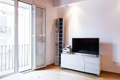 a living room with a flat screen tv on a dresser at Moderno y auténtico en el corazón de Poble Sec in Barcelona