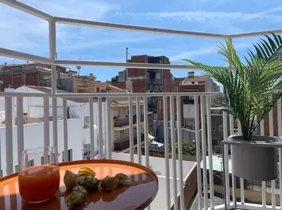 a balcony with a table and a view of a city at Jordi home 15 minutes to center by train in Sant Adria de Besos
