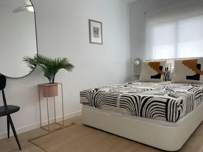 a bedroom with a zebra print bed with a potted plant at Jordi home 15 minutes to center by train in Sant Adria de Besos