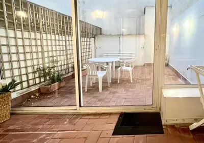 a patio with a table and chairs on a balcony at Espacioso con patio interior in Sabadell