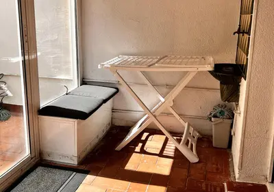 a small table and a stool in a small room at Espacioso con patio interior in Sabadell