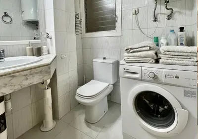 a bathroom with a washing machine and a sink at Espacioso con patio interior in Sabadell