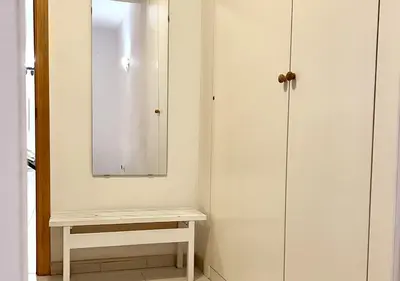a bathroom with a white cabinet and a bench at Espacioso con patio interior in Sabadell
