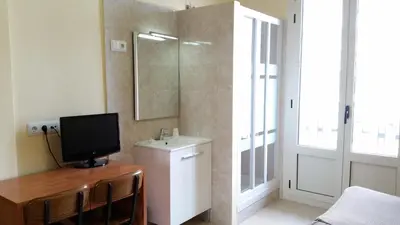 a room with a television on a desk with a mirror at Hostal Capitol Ramblas in Barcelona
