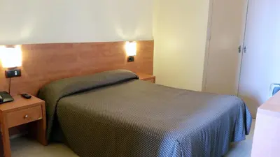 a bedroom with a bed and a table and lights at Hostal Capitol Ramblas in Barcelona