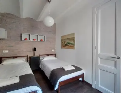 a bedroom with two beds and a door with a window at Barceloneta Beach Apartments in Barcelona