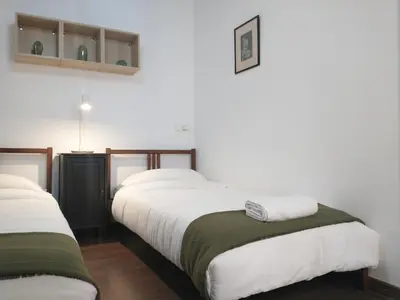 two beds in a room with white walls at Barceloneta Beach Apartments in Barcelona