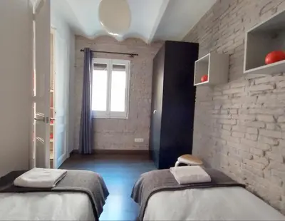 a room with two beds and a brick wall at Barceloneta Beach Apartments in Barcelona