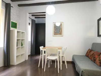 a living room with a table and chairs and a couch at Barceloneta Beach Apartments in Barcelona
