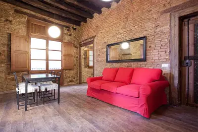 a red couch in a room with a brick wall at El Born - Barcelona Center Apartment in Barcelona