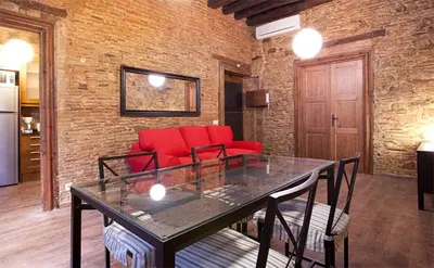 a living room with a table and a red couch at El Born - Barcelona Center Apartment in Barcelona
