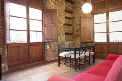 a dining room with a table and chairs and windows at El Born - Barcelona Center Apartment in Barcelona