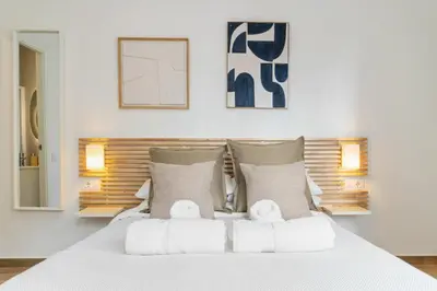 a bedroom with a large white bed with two towels at Livinn House - Self Check in in Hospitalet de Llobregat