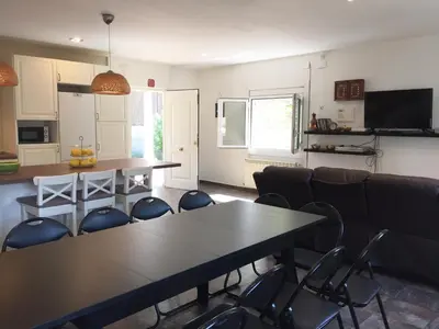 a room with a table and chairs and a kitchen at Eco house of oak, 15 min to BCN Max Pax 8 in Sant Cugat del Vallès