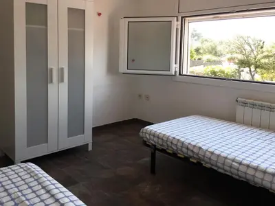 a room with two beds and a window at Eco house of oak, 15 min to BCN Max Pax 8 in Sant Cugat del Vallès