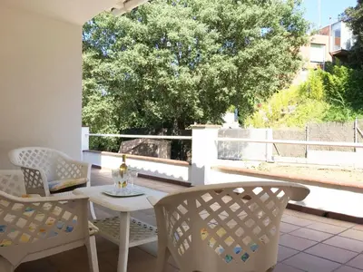 a patio with a table and chairs and a tree at Eco house of oak, 15 min to BCN Max Pax 8 in Sant Cugat del Vallès