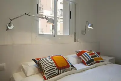 a bedroom with a bed with two pillows and a window at Barceloneta near Beach Apartments in Barcelona
