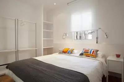 a white bedroom with a large bed with pillows at Barceloneta near Beach Apartments in Barcelona
