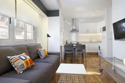 a living room with a couch and a kitchen at Barceloneta near Beach Apartments in Barcelona
